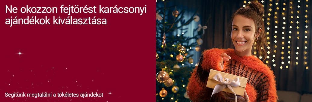 Tóth Andi karácsonyfa mellett tart egy ajándékdobozt. Felirat: Ne okozzon fejtörést a karácsonyi ajándékok kiválasztása