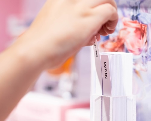 hand pulling out a perfume stick